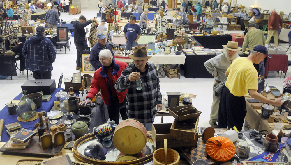 People examine items for sale during the antique show Sunday in Augusta.