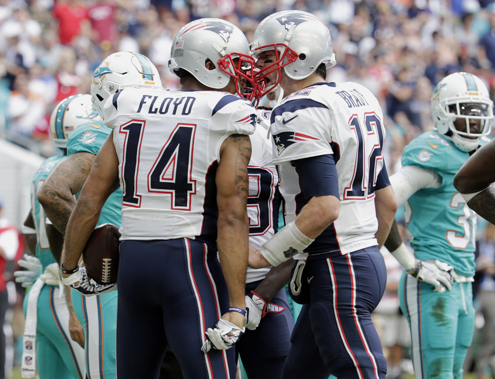 New England Patriots quarterback Tom Brady congratulates wide receiver Michael Floyd after Floyd scored a touchdown, during the first half Sunday against the Miami Dolphins in Miami Gardens, Fla. The Patriots won 35-14 and clinched home field advantage throughout the playoffs.