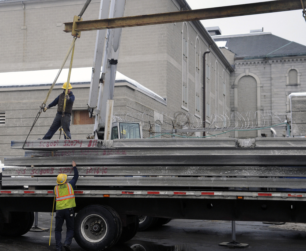 Workers lift material inside the Kennebec County Correctional Facility Tuesday as renovations and an expansion begins.