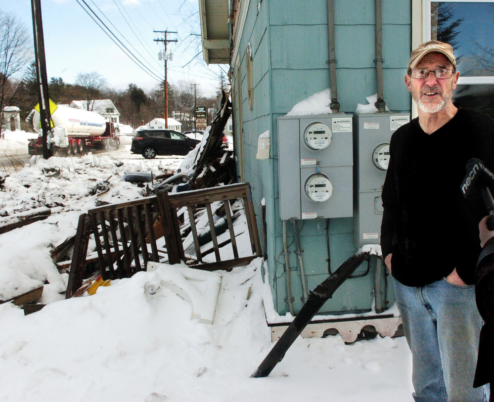 As a truck passes by Wednesday, homeowner Richard Faeth talks about the Tuesday evening truck accident that destroyed the porch in front of his home on Fairbanks Road in Farmington.