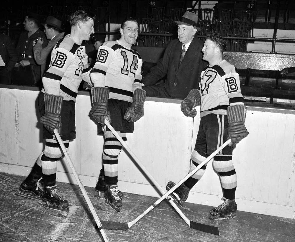 In this October 1945 file photo, Boston Bruins manager "Uncle Arthur" Ross is pictured with his players, from left, Milt Schmidt, Porky Dumart and Bobby Bauer, known as the team's "Kraut Line", during hockey practice at Boston Garden in Boston. Schmidt, a hockey hall of famer, has died at the age of 98. Schmidt, the NHL MVP in 1951, was the league's oldest living former player.