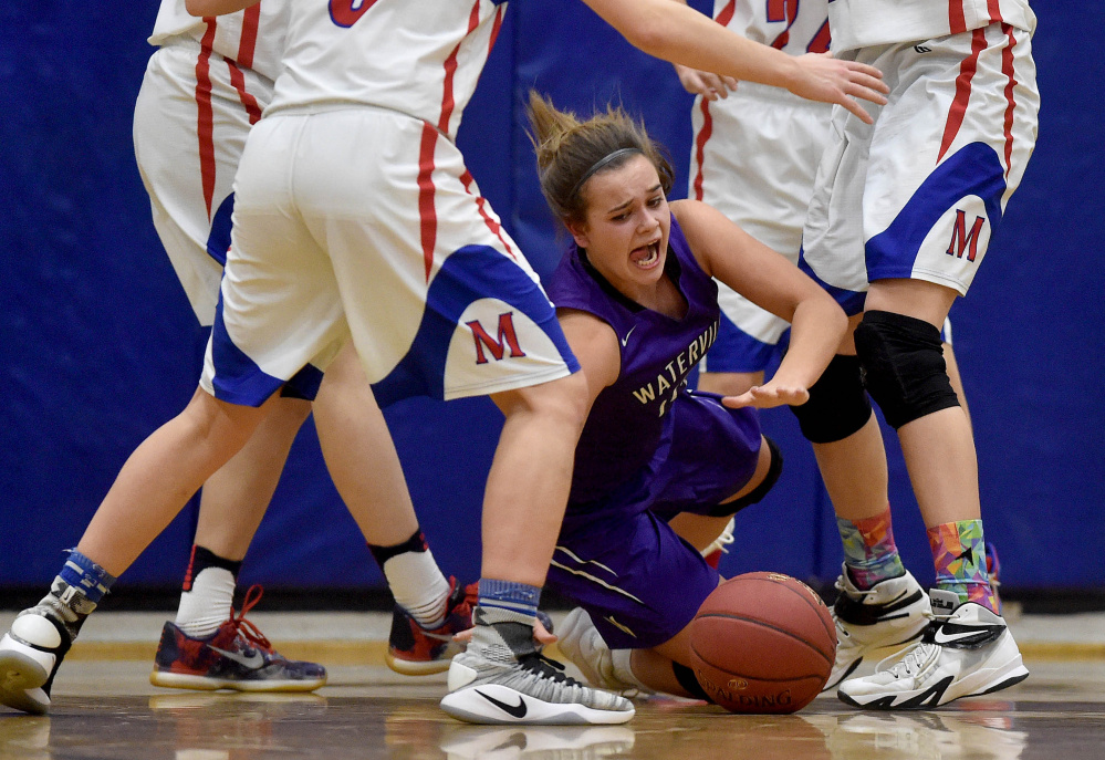 Waterville's Mackenzie St. Pierre falls to the court as she fights for the loose ball against Messalonskee on Wednesday in Oakland.
