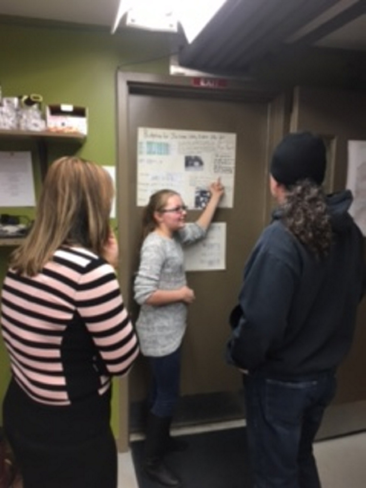 Forest Hills Consolidated School eighth graders Sarah Hoyt, center, studied and reported on financial particulars during Jackman Water District's open house. Jacob Chagnot worked together with Hoyt on their project.