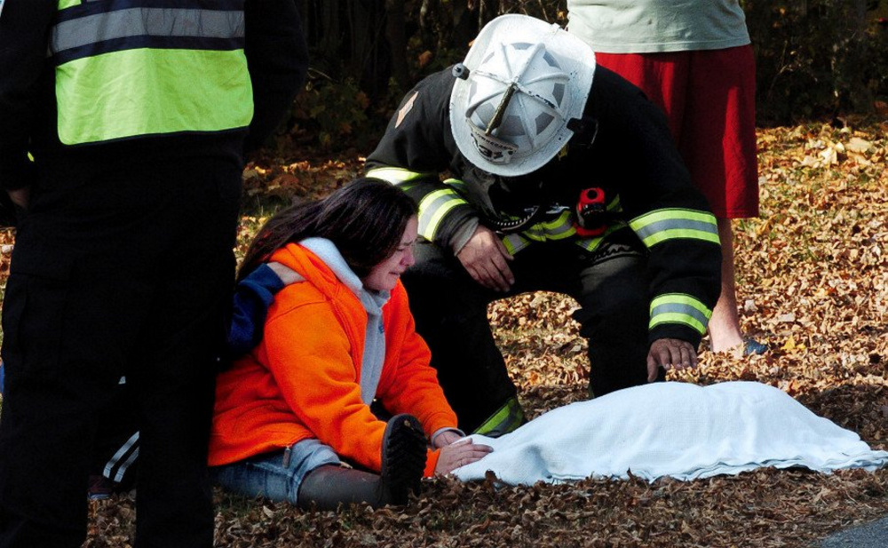 Skowhegan Fire Chief Shawn Howard comforts Danette Dalton on Nov. 2 after he carried her deceased dog out of her home on Cote Street in Skowhegan, which a fire had damaged beyond repair.