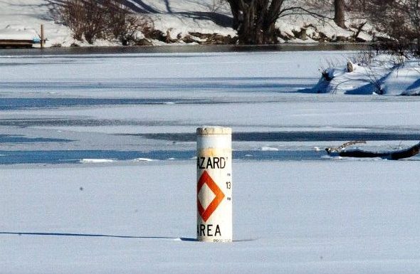 A hazard buoy marks the area near the outlet dam on Messalonskee Lake in Oakland where a moving current tends to reduce the thickness of the ice. Snowmobiler Richard Dumont died Saturday after his snowmobile broke through the ice at the spot where a log, seen in background, was left.