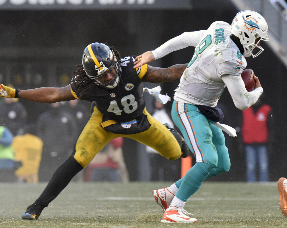 Miami Dolphins quarterback Matt Moore eludes the grasp of Pittsburgh outside linebacker Bud Dupree during the second half Sunday in Pittsburgh.