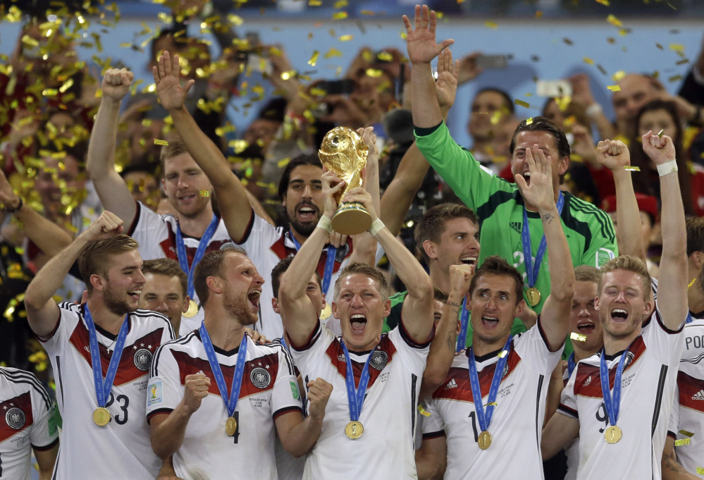 In this July 13, 2014 photo Germany's Bastian Schweinsteiger holds up the World Cup trophy as the team celebrates their 1-0 victory over Argentina after the World Cup final soccer match at the Maracana Stadium in Rio de Janeiro, Brazil. FIFA is about to make the World Cup a bigger and, it hopes, richer event even at the cost of lower quality soccer.