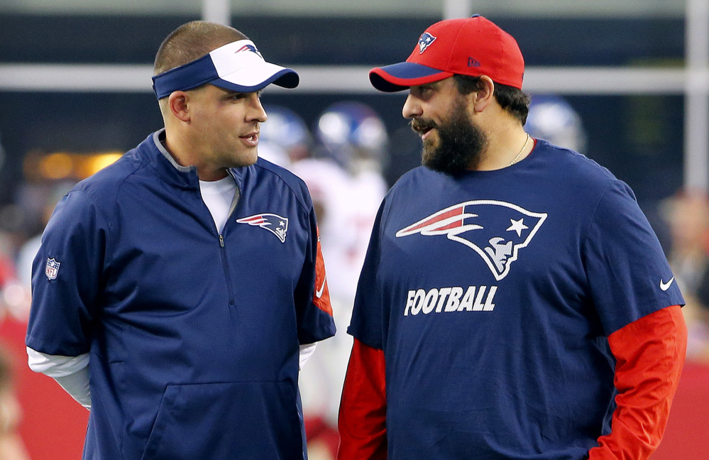 New England Patriots offensive coordinator Josh McDaniels, left, talks with defensive coordinator Matt Patricia before a 2015 game against the New York Giants in Foxborough, Massachusetts.