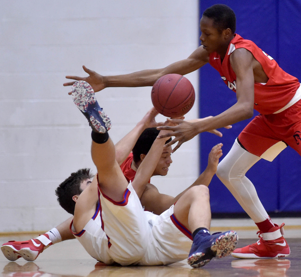 Messalonskee's Chase Warren, foreground, battles for the loose ball with Cony's Jordan Roddy, back, and Amahde Carter, right, Saturday in Oakland.
