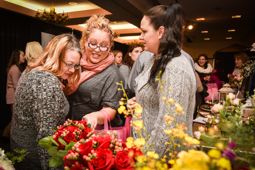 The Bridal Expo at the Augusta Civic Center attracted a large crowd. Shown here inspecting floral options are, left to right, Amber Dyer of Clinton, Rachel Lane of Benton and Ashley Ferris of Shawmut.