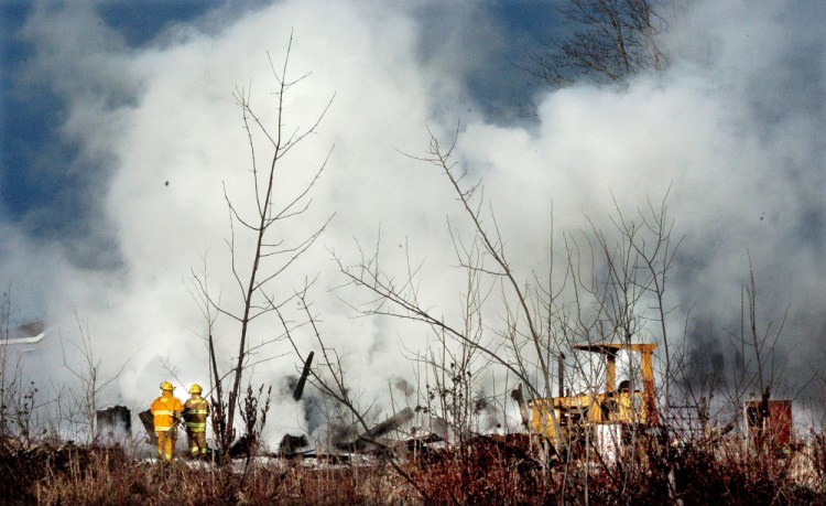 Smoke rises as firefighters put out the fire that flattened a building on the Whitten Road in Burnham on Monday.