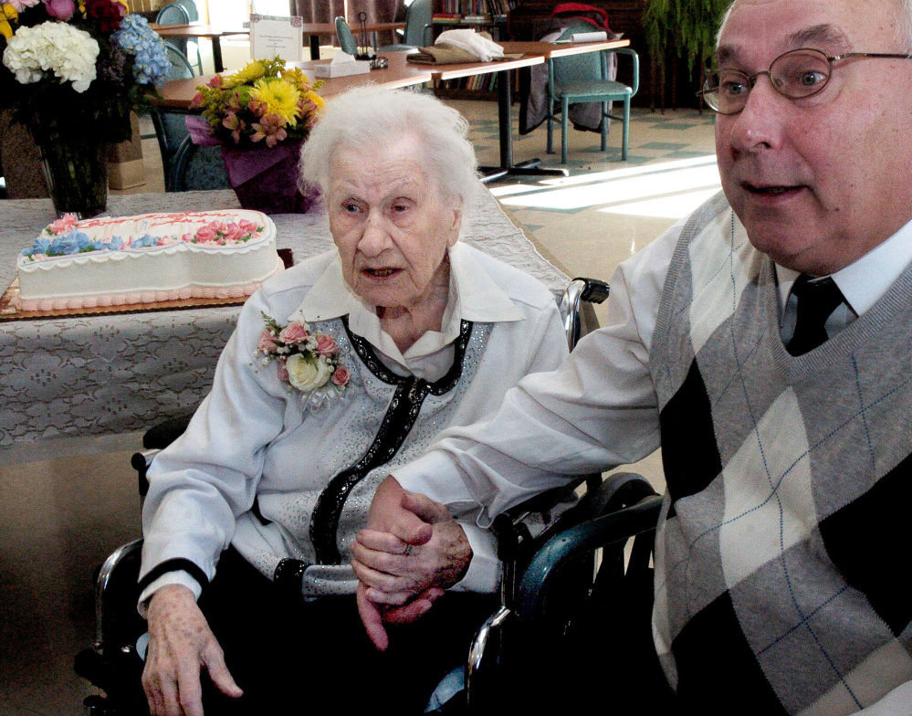 Ann Labin and her son David hold hands while talking about her long life prior to her 100th birthday party at the Maple Crest Home in Madison on Monday.