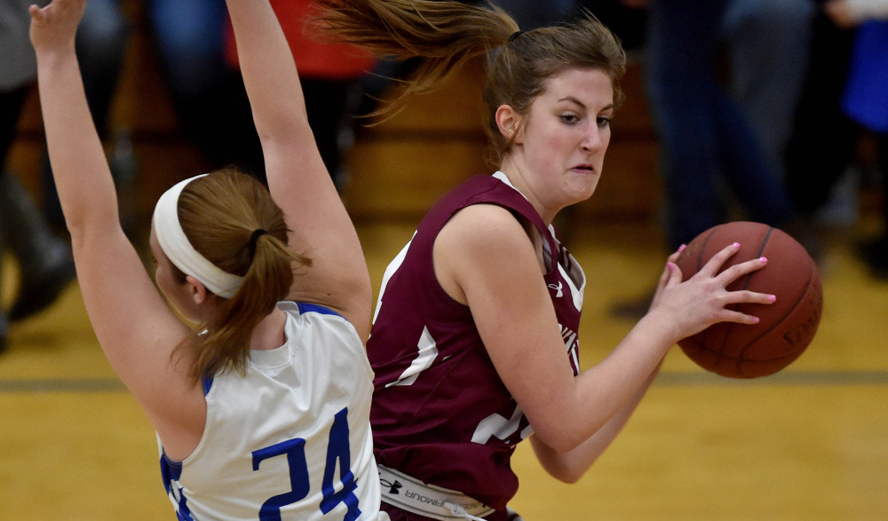 Madison junior forward Marah Hall fouls Monmouth forward Kaeti Butterfield during a Mountain Valley Conference game Tuesday night.