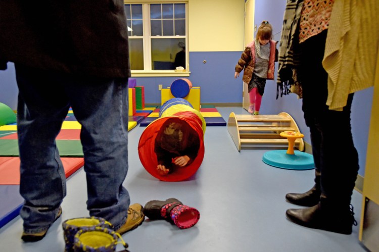 Scott Weston, 7, crawls through a rainbow wormhole as his sister Cecily, 4, right, takes the high road in the Gross Motor Room at a Woodfords Family Services preschool during school's the grand opening Thursday in Waterville.