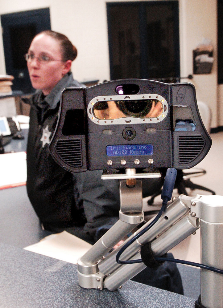 Somerset County Jail Corrections Officer Shannon Pooler talks about the iris scanner, foreground, that is used on inmates arriving at the intake section of the jail Thursday in East Madison. The iris scanner and a nearby body scanner are high-tech devices used to detect contraband and identify inmates.