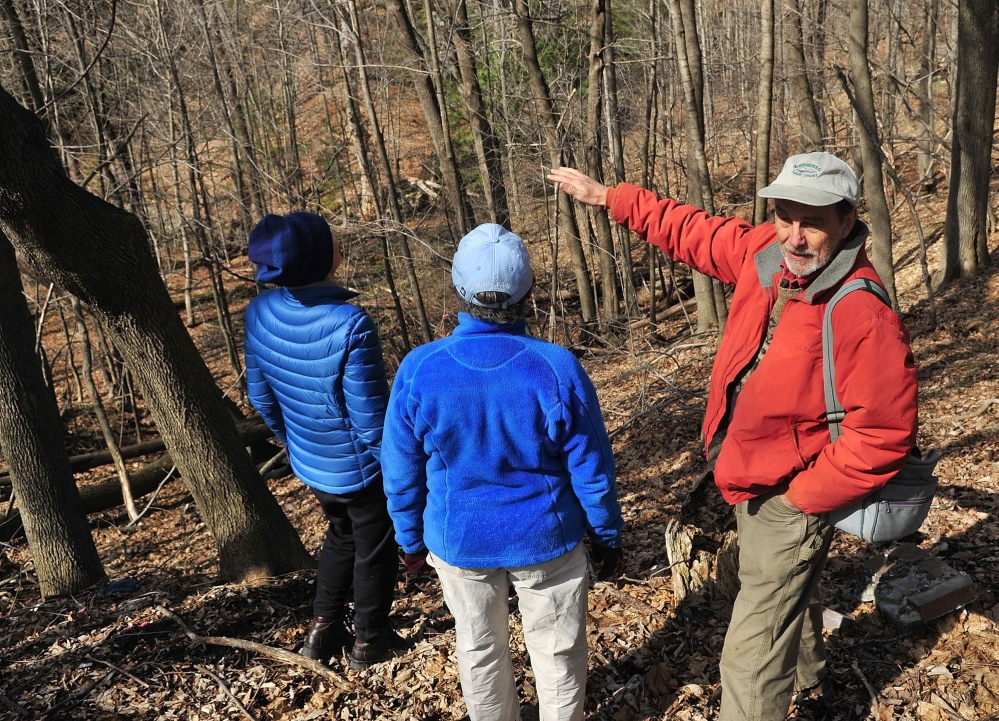 Sue Bell, left, City Councilor Dale McCormick and Brian Kent look down on Kennedy Brook on April 18, 2014, during a walking tour of Howard Hill in Augusta. The Augusta City Council voted Thursday night to accept the land from the Kennebec Land Trust.