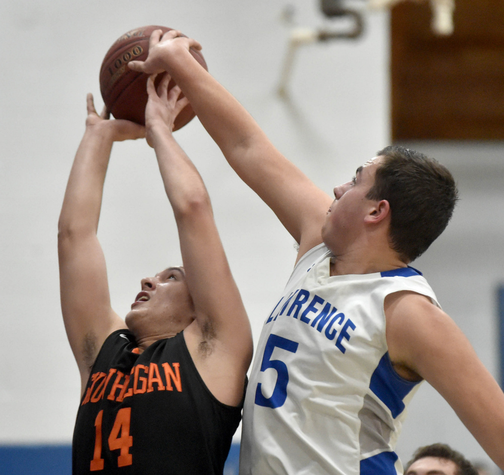 Lawrence junior Braden Ballard (5) rejects a shot by Skowhegan senior Joadel Mora during a Kennebec Valley Athletic Conference Class A game  Friday night in Fairfield.