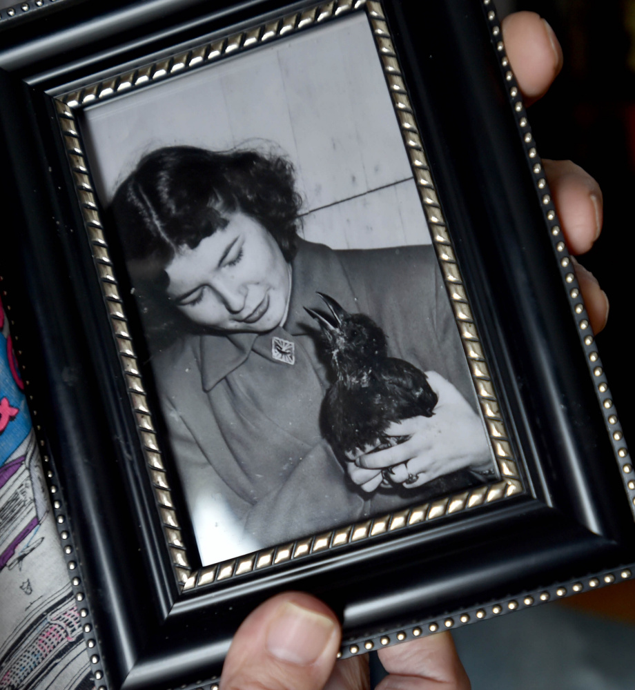 Lee Bureau holds a photo of his sister Joy and their pet crow, Smokey.