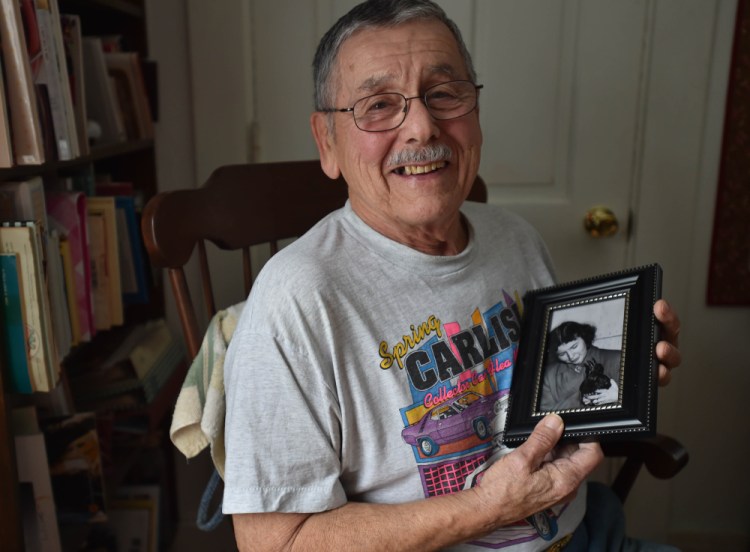 Lee Bureau poses for a portrait with a photo of his sister Joy and their pet crow, Smokey, at his home in Waterville on Friday. Smokey the crow, remembered as a smart and mischievous bird, died in 1952.