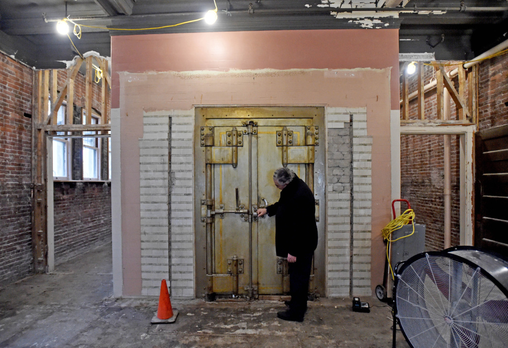 Paul Ureneck, director of commercial real estate for Colby College, inspects the 1902 era safe from the former Waterville Savings Bank that first inhabited the former Hains Building, which is being renovated as part of a $5 million project.