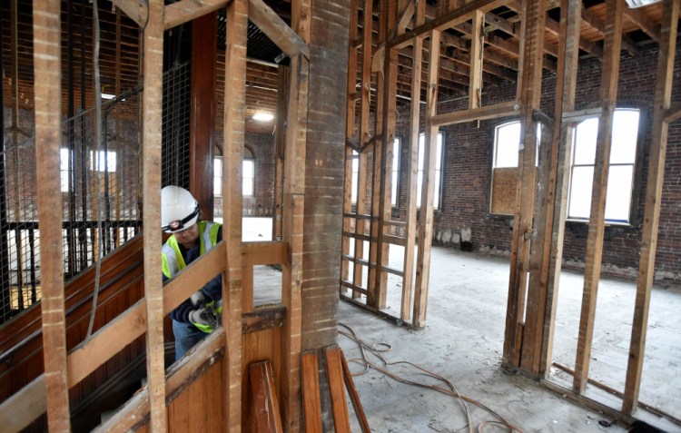 Connie Damboise works on the top floor of the former Hains Building on Main Street in Waterville on Friday. The building at 173 Main St. is being renovated as part of a $5 million project.
