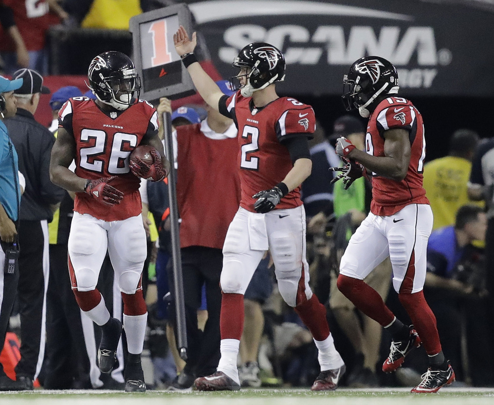 Atlanta quarterback Matt Ryan congratulates Tevin Coleman, left, after Coleman's touchdown run during the second half against Green Bay in the NFC championship game Sunday in Atlanta.