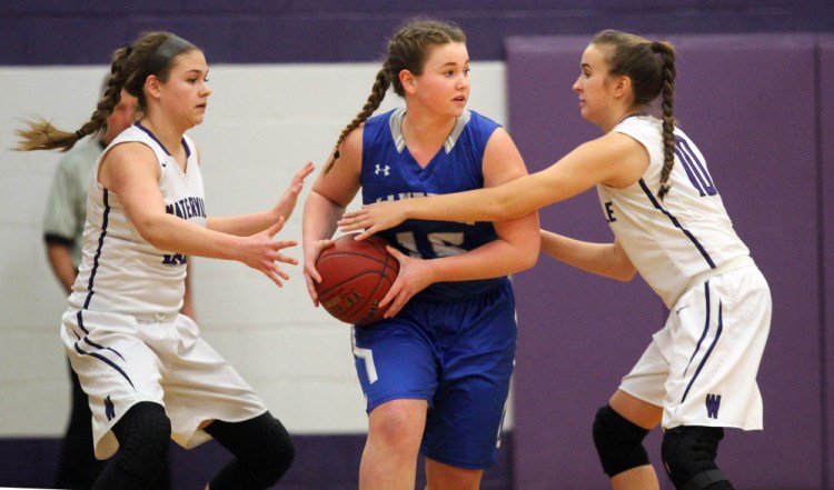 Lawrence's Hunter Mercier, center, tries to escape pressure by Waterville's Madeleine Martin, left, and Sophie Webb, right, during first-half action Wednesday in Waterville.