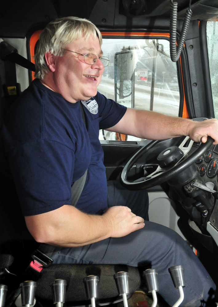 Waterville Public Works employee Dan Wilson sits next to various controls used to operate a department plow truck while clearing snow from the storm on Tuesday.