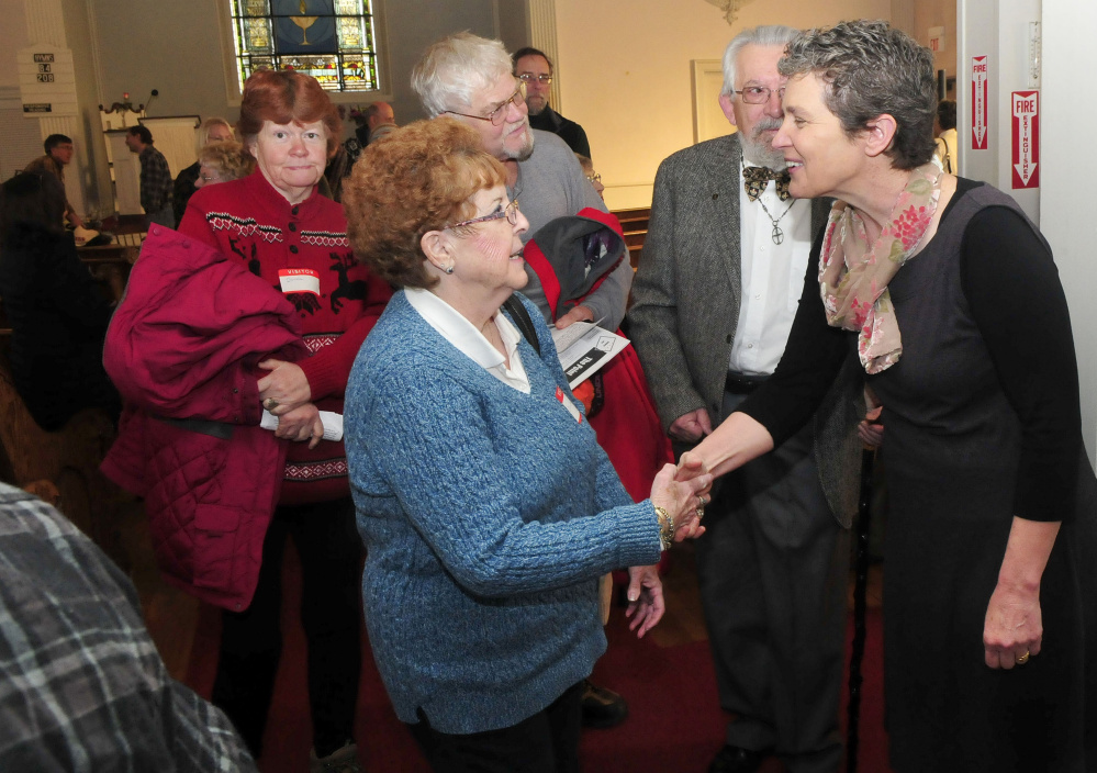 Kate Braestruo, right, a game warden and police chaplain, greets parishioners including Coreine Fletcher of Palmyra, following her address at the Universalist Unitarian Church in Waterville on Sunday.