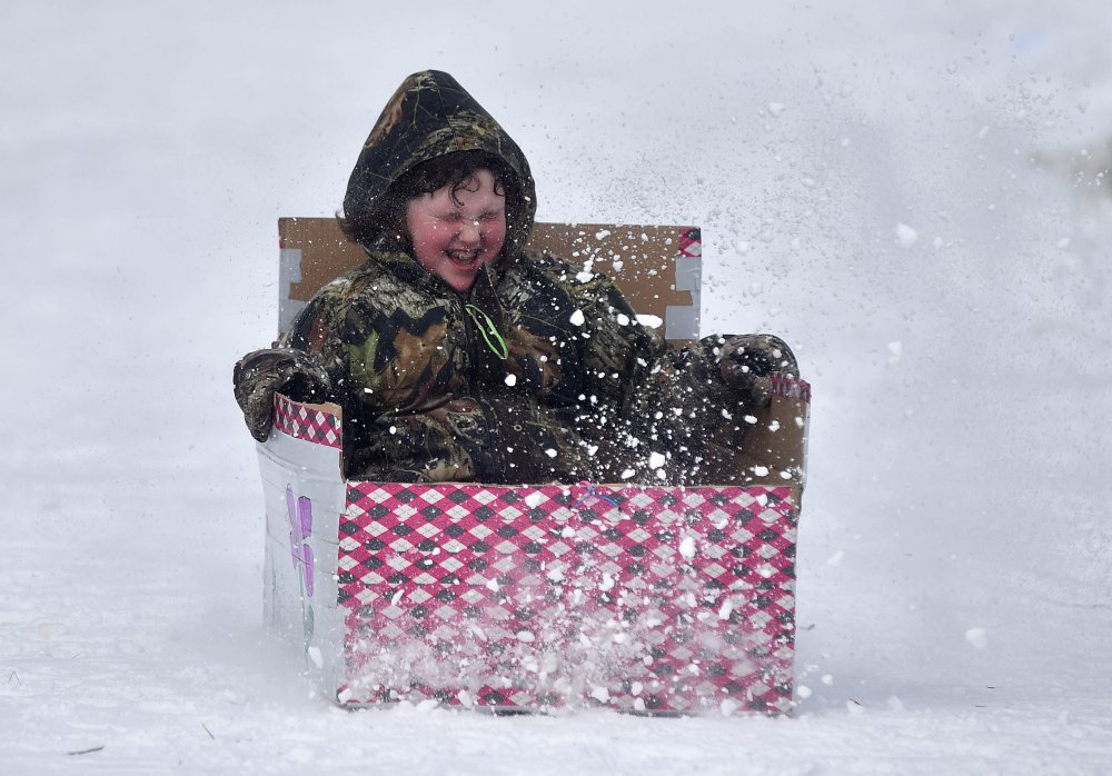 A competitor in the box sled races zips through a spray of snow last year at the annual winter carnival at Lake George Regional Park in Skowhegan. This year's annual carnival gets underway Saturday.