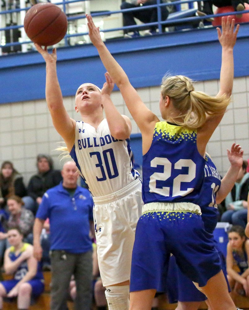 Madison's Madeline Wood, left, gets by Mt. Abram defenders Megan Sorel and Shania Campbell for a layup Tuesday.