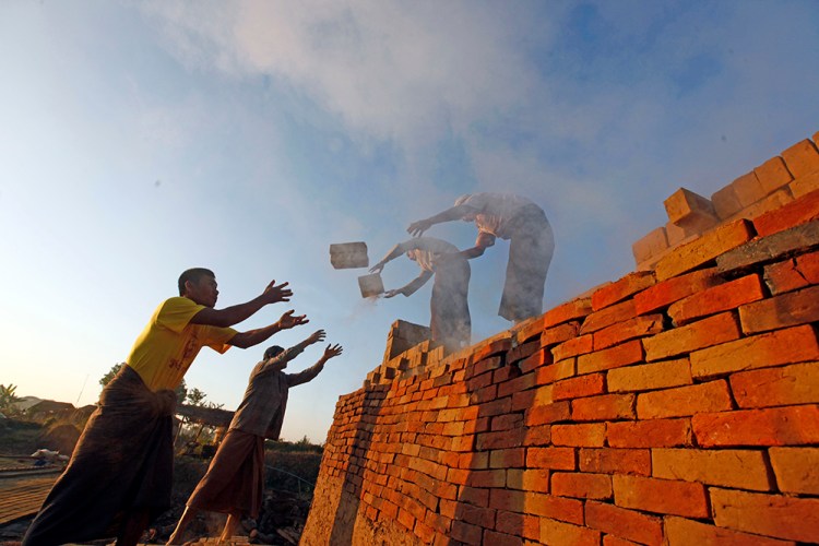 Workers unload bricks at a brick-making factory in Naypyitaw, Myanmar.  "It is obscene for so much wealth to be held in the hands of so few when 1 in 10 people survive on less than $2 a day," says Winnie Byanyima, executive director of Oxfam International. "Inequality is trapping hundreds of millions in poverty; it is fracturing our societies and undermining democracy."