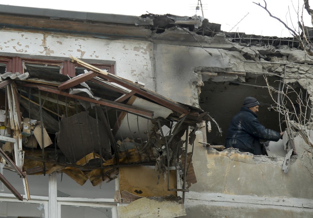 A municipal worker inspects damage to a home after shelling struck the city of Donetsk, eastern Ukraine, on Wednesday. At least 10 have been killed since Monday.