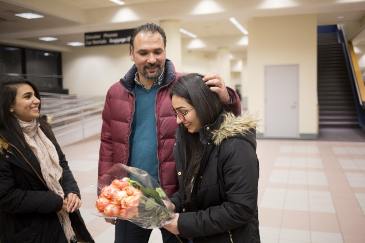 Banah Al-Hanfy, right, her uncle Aqeel Mohialdeen and her sister Jumana Al-Hanfy wait for U.S. Rep. Chellie Pingree to join them at the Portland airport on Feb. 3. Pingree's office and others from various organizations worked together to help get Al-Hanfy reunited with her family.