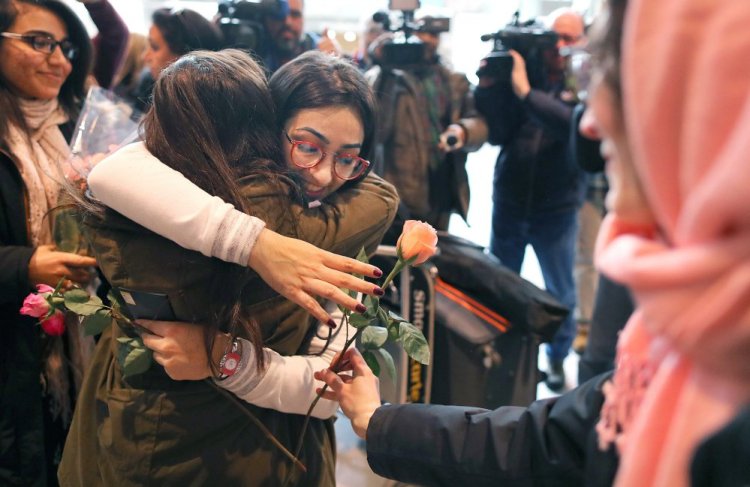Banah Al-Hanfy gets a hug and a rose after arriving at Logan International Airport on Friday. She met her parents and sisters after being delayed for a week by President Trump's executive order on immigration, which was stayed by a federal judge Friday night.