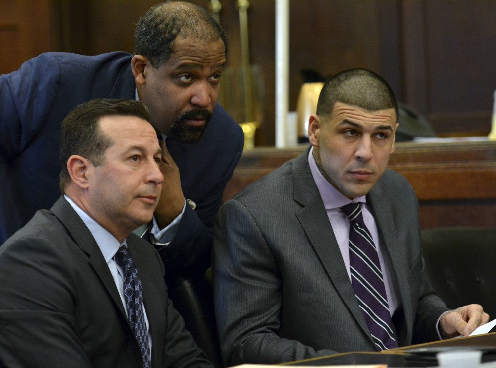 Lead defense attorney Jose Baez, from left, defense attorney Ronald Sullivan and Aaron Hernandez listen to Judge Jeffrey Locke during a hearing requesting a continuance Friday in Boston for Hernandez's upcoming double-murder trial.