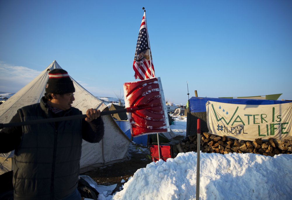 Benji Buffalo shovels snow at a camp in Cannon Ball, N.D., where people are protesting the Dakota Access Pipeline.
