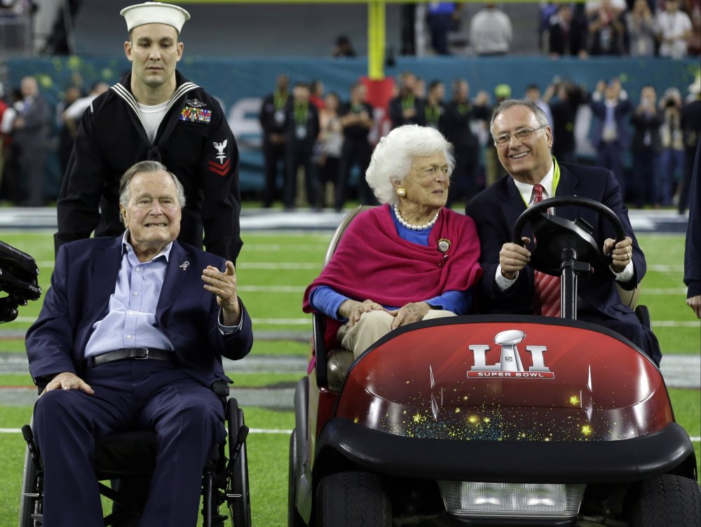 Former President George H.W. Bush and wife, Barbara, are escorted onto the field at NRG Stadium for the pregame coin toss before the Super Bowl in Houston on Sunday.