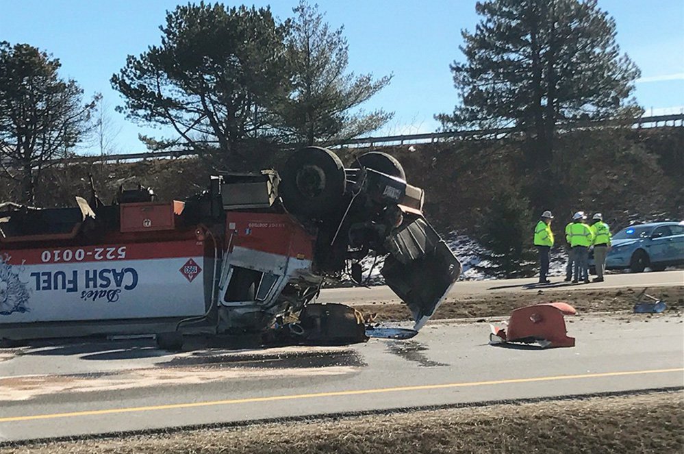 An oil tanker rests on its top in the northbound lanes of I-295 in South Portland late Monday morning.