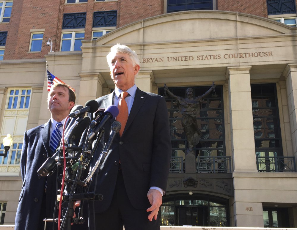 Virginia Attorney General Mark Herring, right, accompanied by Virginia Solicitor General Stuart Raphael, speaks outside the federal courthouse in Alexandria, Va., on Friday following a hearing on President Trump's travel ban.