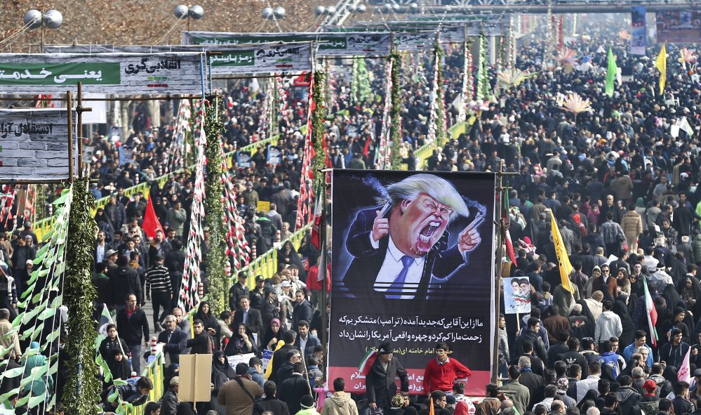 Iranians carry a banner showing a caricature of President Trump during an annual rally commemorating the 1979 Islamic revolution, which toppled the pro-U.S. Shah, Mohammad Reza Pahlavi, in Tehran, Iran.