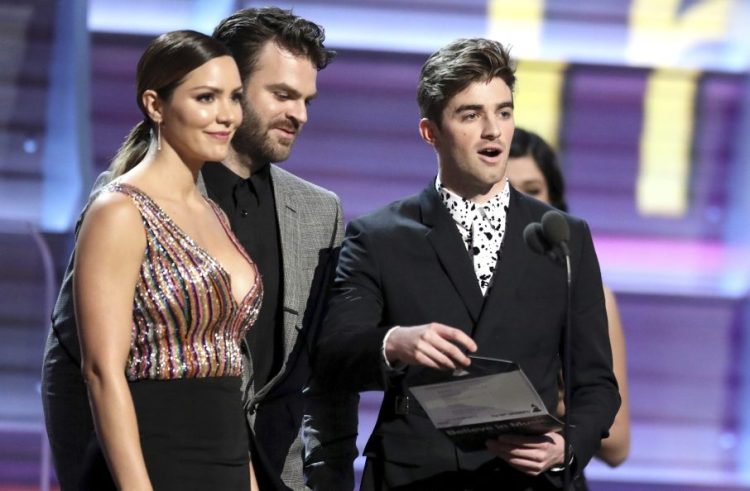 From left, Katharine McPhee and The Chainsmokers' Alex Pall and Drew Taggart present the award for best rock song Sunday at the 59th annual Grammy Awards in Los Angeles.