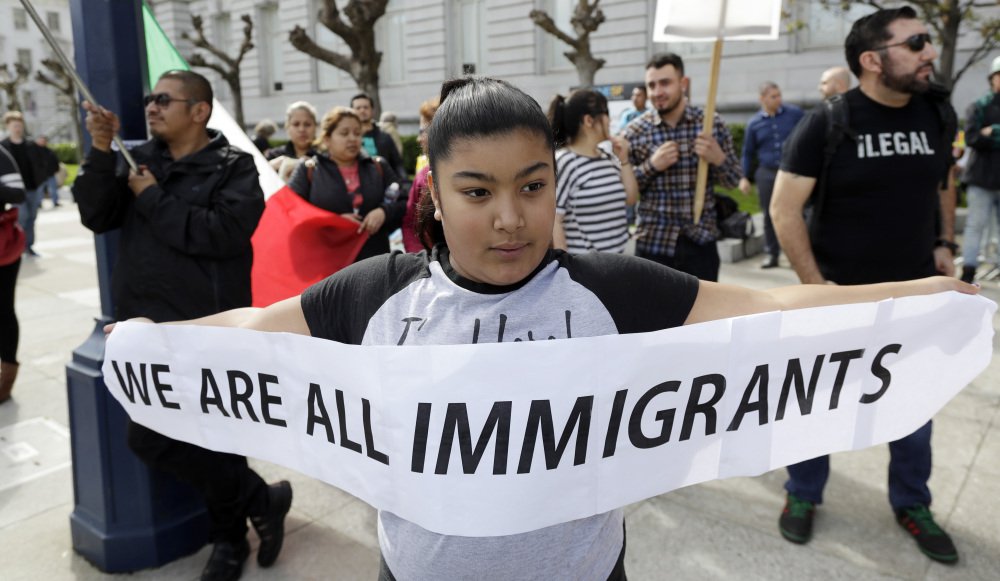 Delilah Gutierrez, 10, left, holds a sign during a protest against President Donald Trump's efforts to crack down on immigration on Thursday in San Francisco.