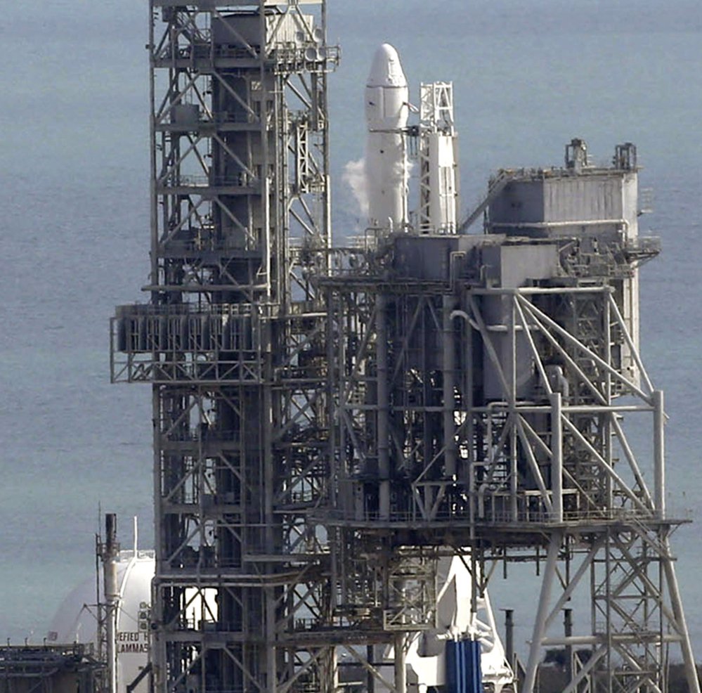The Falcon remains at Kennedy Space Center in Cape Canaveral, Fla., where its scheduled Saturday launch had to be postponed for what was called a minor problem.