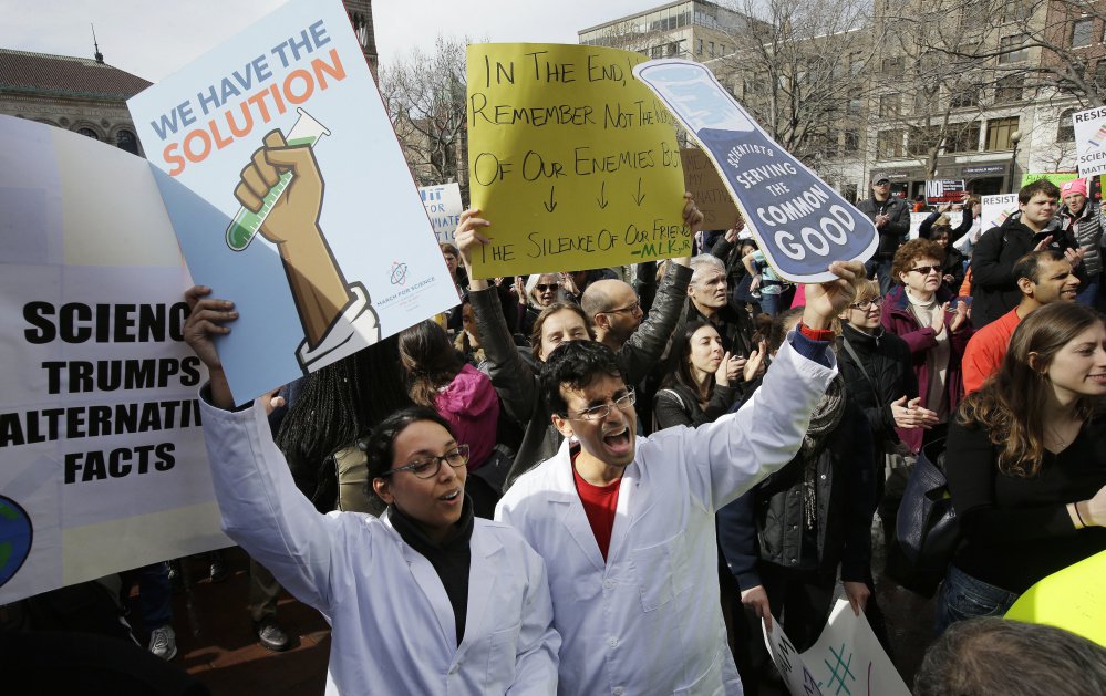 Neuroscientist Shruti Muralidhar, front left, and microbiologist Abhishek Chari, front right, demonstrate Sunday in Boston.