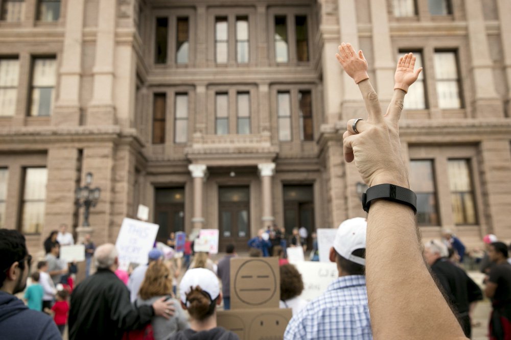 Peter Costa of Windham, N.H., gestures at Monday's "Not My President" rally in Austin, Texas. Protests were held across the country, but crowds were smaller than seen at President Trump's inauguration. Police arrested some unruly protesters in Oregon.