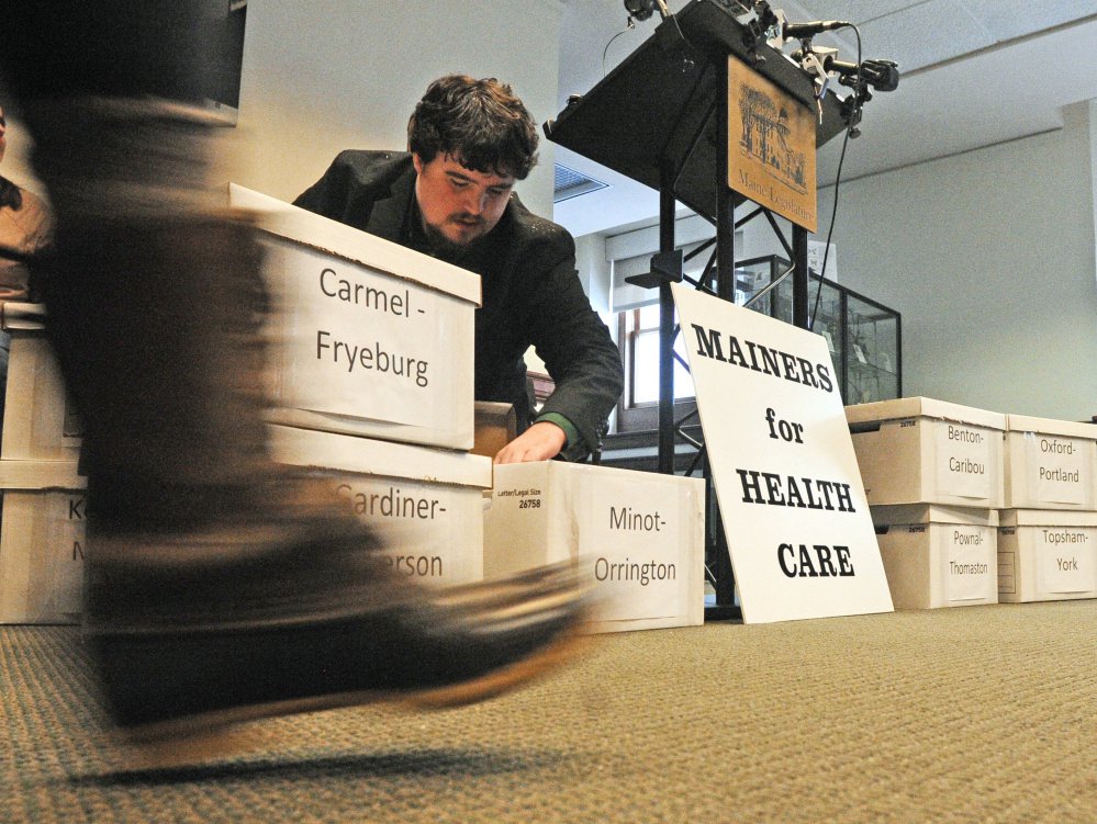 Sam Portera, Greater Bangor organizer for Maine People's Alliance, sorts through petitions prior to a Mainers For Health Care news conference last month at the State House in Augusta. Enough petitions were collected to place a referendum on the ballot to ask whether Mainers want to expand Medicaid coverage.