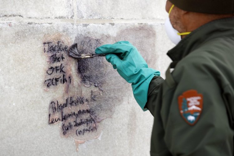 A U.S. Park Service employee works to clean graffiti off of the Washington Monument, Tuesday, Feb. 21, 2017, in Washington. U.S. Park Police spokeswoman Sgt. Anna Rose said that the messages written in permanent marker were discovered over the holiday weekend at the Lincoln Memorial, the Washington Monument and the World War II Memorial. (AP Photo/Alex Brandon)
