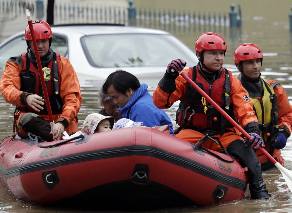 Rescue crews ferry residents from a flooded neighborhood Tuesday in San Jose, Calif. About half the state remains under flood, wind and snow advisories.