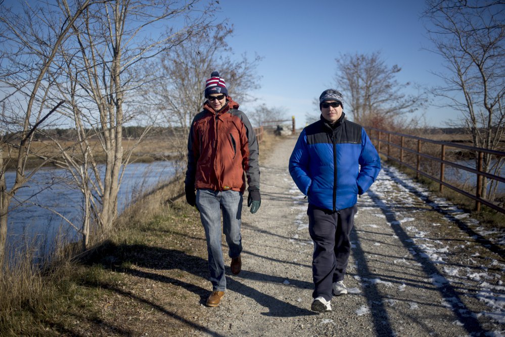 Ron Currier, left, and Jack Currier of Scarborough walk in December on the section of the Eastern Trail that goes through the Scarborough Marsh. The Eastern Trail Alliance is raising money to build two bridges that would fill gaps in the trail in Scarborough.